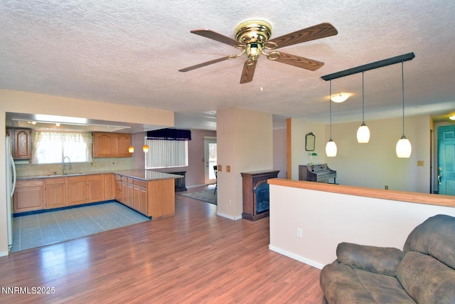 35 Count Fleet Ct, Reno, NV 89502 - kitchen featuring open floor plan, a peninsula, a textured ceiling, wood finished floors, and ceiling fan