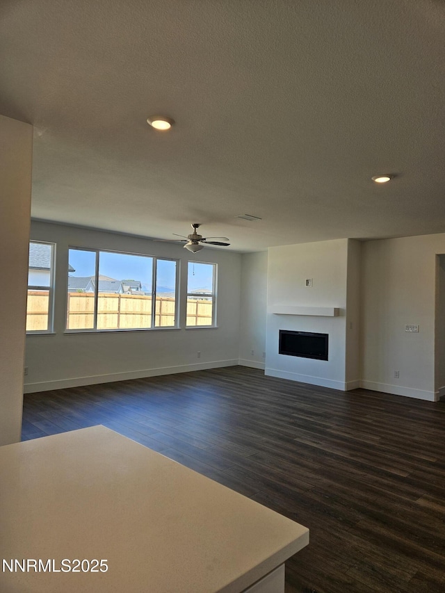 1224 Heybourne Rd, Gardnerville, NV 89410 - unfurnished living room featuring dark wood-style flooring, baseboards, recessed lighting, a fireplace, and a ceiling fan