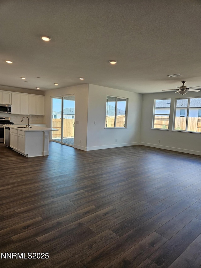 1224 Heybourne Rd, Gardnerville, NV 89410 - unfurnished living room featuring a sink, dark wood-style flooring, healthy amount of natural light, and recessed lighting