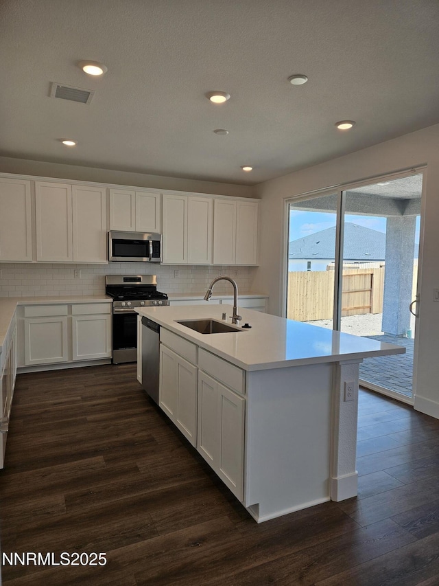 1224 Heybourne Rd, Gardnerville, NV 89410 - kitchen featuring appliances with stainless steel finishes, a sink, dark wood-type flooring, white cabinets, and tasteful backsplash