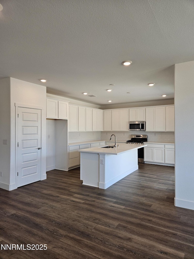 1224 Heybourne Rd, Gardnerville, NV 89410 - kitchen featuring stainless steel appliances, a sink, white cabinets, tasteful backsplash, and dark wood-style floors