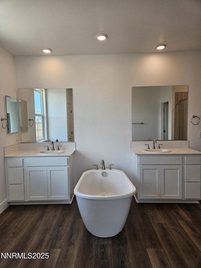 1224 Heybourne Rd, Gardnerville, NV 89410 - full bath with wood finished floors, a soaking tub, two vanities, and recessed lighting