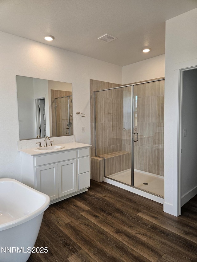 1224 Heybourne Rd, Gardnerville, NV 89410 - full bath featuring a soaking tub, vanity, wood finished floors, a stall shower, and recessed lighting