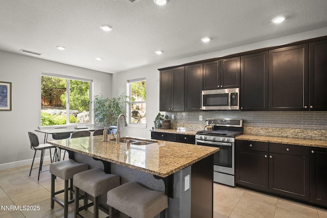 1775 Samantha Crest Trl, Reno, NV 89523 - kitchen with stainless steel appliances, backsplash, light stone countertops, light tile patterned floors, and recessed lighting