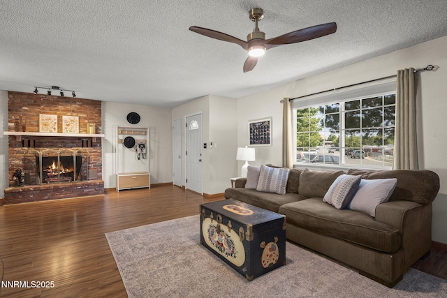 3505 Everett Dr, Reno, NV 89503 - living area with rail lighting, a ceiling fan, wood finished floors, a textured ceiling, and a brick fireplace