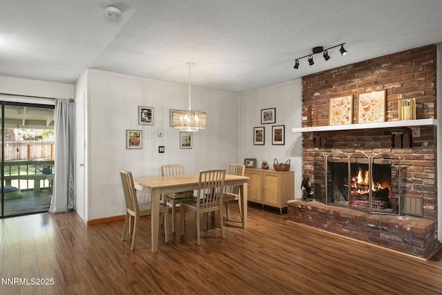 3505 Everett Dr, Reno, NV 89503 - dining area with wood finished floors, a chandelier, track lighting, a brick fireplace, and a textured ceiling