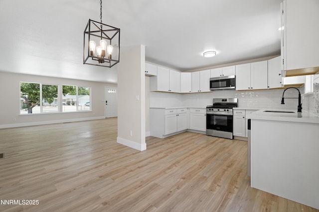 1000 Dwight Way, Dayton, NV 89403 - kitchen featuring stainless steel appliances, a sink, decorative backsplash, light wood-style flooring, and light countertops