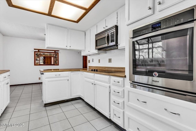 1809 Franklin Rd, Carson City, NV 89706 - kitchen with appliances with stainless steel finishes, white cabinetry, light tile patterned floors, and a peninsula