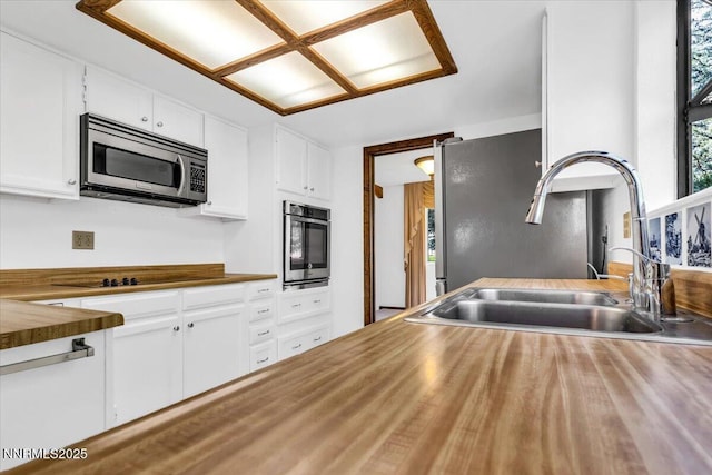 1809 Franklin Rd, Carson City, NV 89706 - kitchen with stainless steel appliances, a sink, butcher block countertops, and white cabinetry