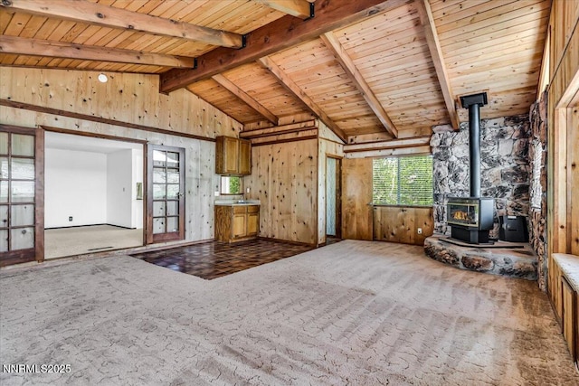1809 Franklin Rd, Carson City, NV 89706 - unfurnished living room featuring carpet, a wood stove, wooden ceiling, and wooden walls
