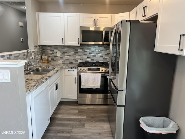7785 Crystal Shores Dr, Reno, NV 89506 - kitchen featuring stainless steel appliances, white cabinetry, light stone countertops, and dark wood finished floors