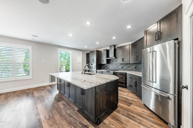 2978 Fox Trail Dr, Reno, NV 89523 - kitchen featuring stainless steel appliances, wall chimney range hood, decorative backsplash, recessed lighting, and an island with sink