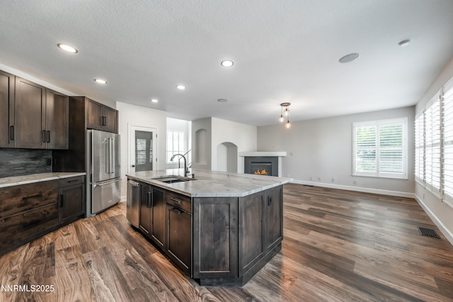 2978 Fox Trail Dr, Reno, NV 89523 - kitchen featuring appliances with stainless steel finishes, dark brown cabinetry, dark wood-style flooring, recessed lighting, and light stone countertops