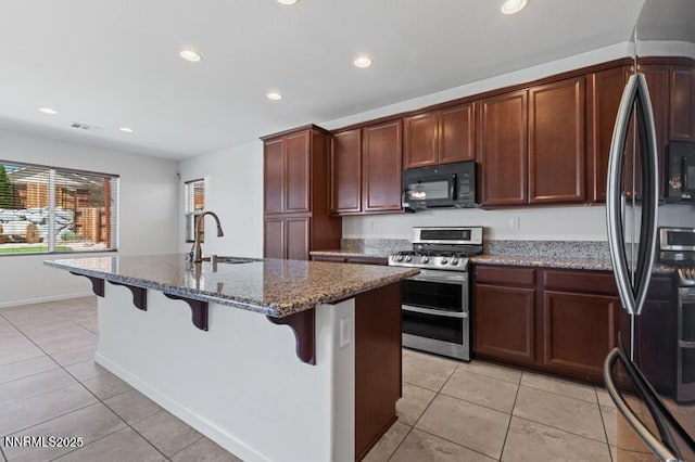 14373 Fredonia Dr, Reno, NV 89506 - kitchen featuring refrigerator with ice dispenser, double oven range, black microwave, light tile patterned flooring, and recessed lighting