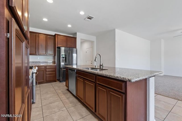14373 Fredonia Dr, Reno, NV 89506 - kitchen with appliances with stainless steel finishes, light tile patterned flooring, light stone counters, a center island with sink, and recessed lighting