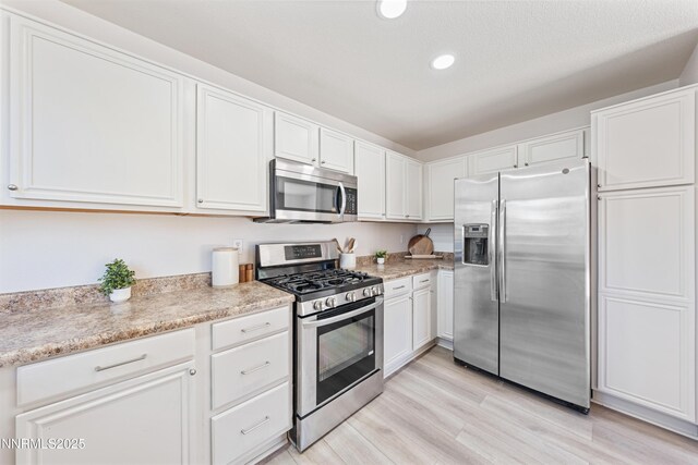 17705 Oakview Ct, Reno, NV 89508 - kitchen featuring stainless steel appliances, white cabinets, recessed lighting, light wood finished floors, and light stone counters