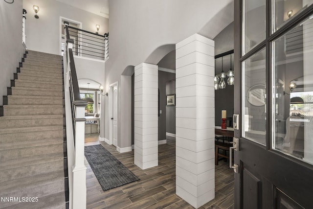 3128 Wild Iris Ct, Sparks, NV 89436 - foyer with arched walkways, dark wood finished floors, stairs, a towering ceiling, and ornate columns