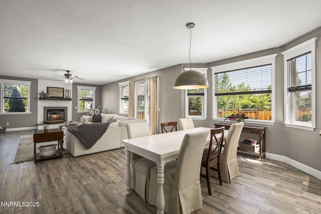 3128 Wild Iris Ct, Sparks, NV 89436 - dining space with dark wood-type flooring, a ceiling fan, and a fireplace