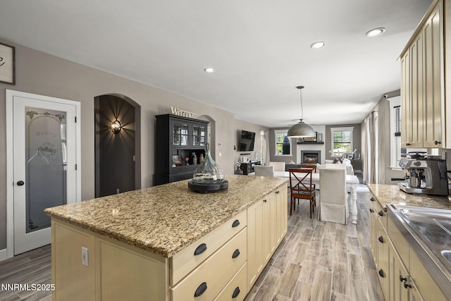 3128 Wild Iris Ct, Sparks, NV 89436 - kitchen with cream cabinetry, a center island, open floor plan, light wood-style floors, and recessed lighting
