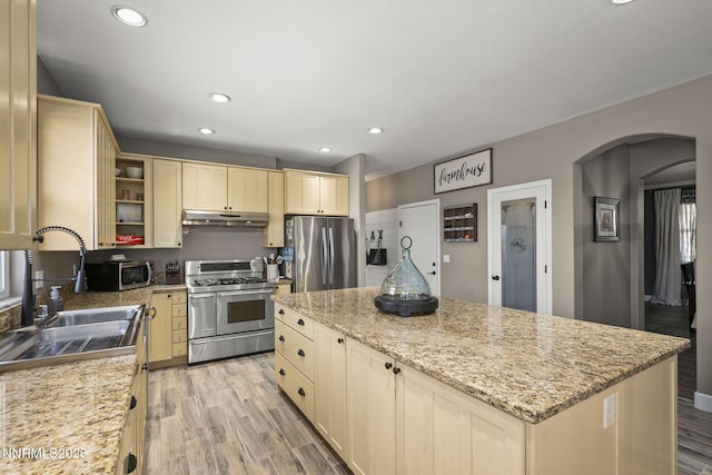 3128 Wild Iris Ct, Sparks, NV 89436 - kitchen featuring appliances with stainless steel finishes, under cabinet range hood, a center island, arched walkways, and recessed lighting