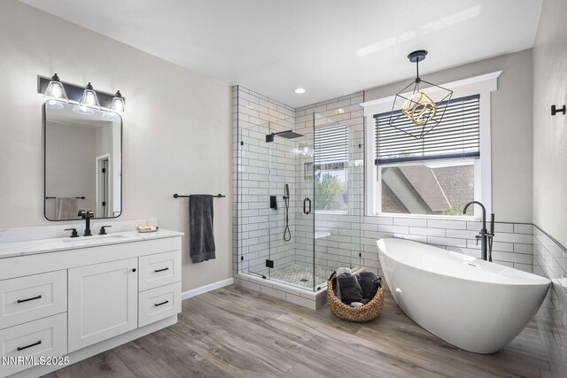 3128 Wild Iris Ct, Sparks, NV 89436 - bathroom featuring a stall shower, a freestanding bath, a chandelier, vanity, and wood finished floors