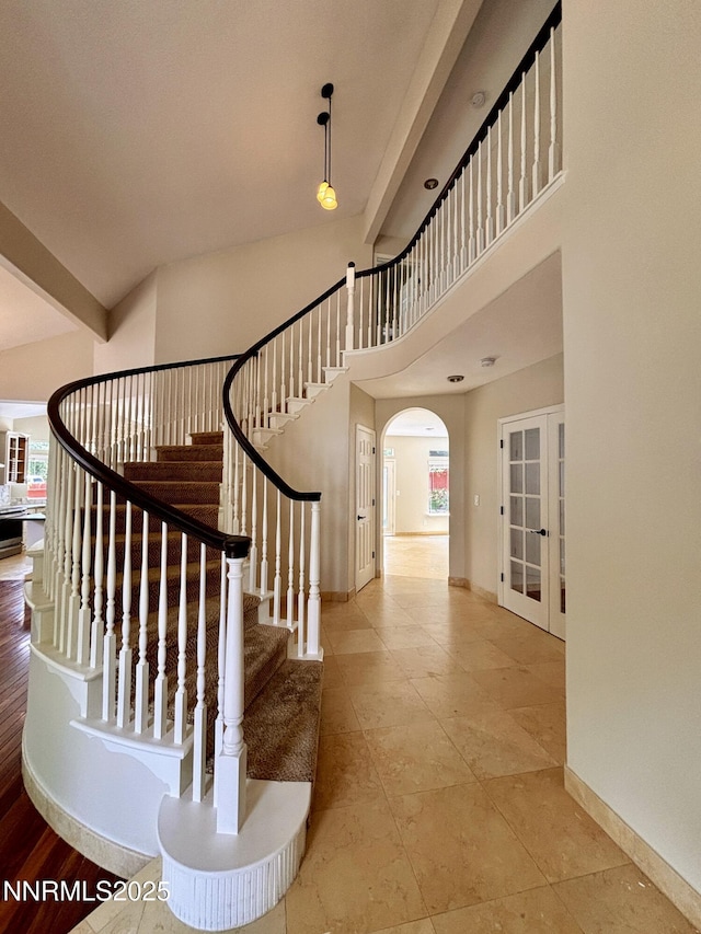 3882 Streamside Ct, Reno, NV 89519 - stairs featuring arched walkways, french doors, and a high ceiling