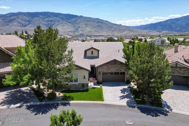 8692 18th Hole Trl, Reno, NV 89523 - view of front of home featuring stone siding, a mountain view, an attached garage, and driveway