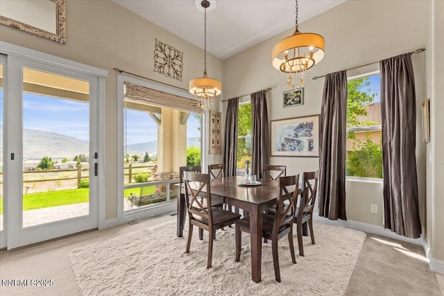 8692 18th Hole Trl, Reno, NV 89523 - dining space with light colored carpet, a mountain view, high vaulted ceiling, and a chandelier