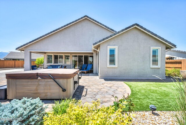 2222 Nasrullah Ln, Reno, NV 89521 - back of property featuring a hot tub, a fenced backyard, a patio, and stucco siding