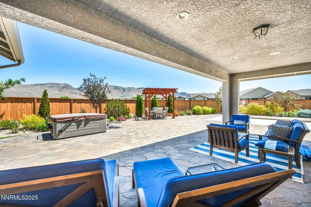2222 Nasrullah Ln, Reno, NV 89521 - fenced backyard featuring a hot tub, a patio, a mountain view, an outdoor hangout area, and outdoor dining space