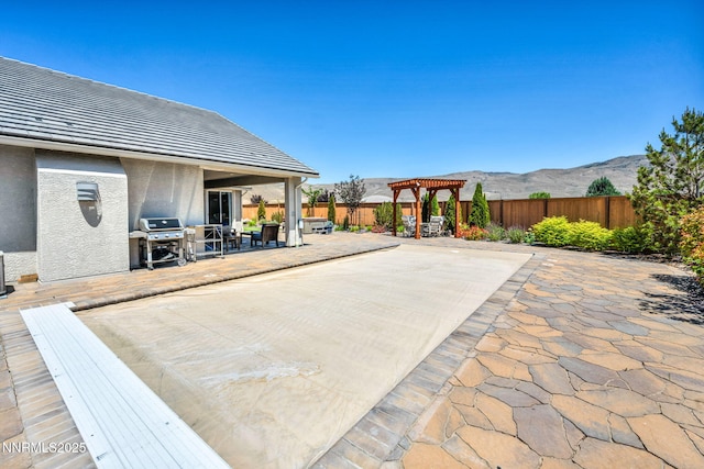 2222 Nasrullah Ln, Reno, NV 89521 - fenced backyard featuring a pergola, a grill, a patio, and a mountain view