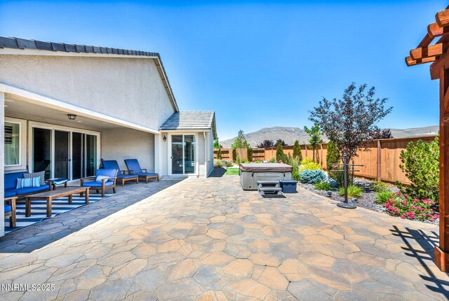 2222 Nasrullah Ln, Reno, NV 89521 - fenced backyard featuring a hot tub, a patio area, a mountain view, and an outdoor hangout area