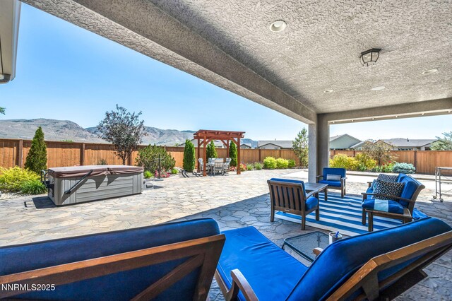 2222 Nasrullah Ln, Reno, NV 89521 - fenced backyard with a hot tub, an outdoor living space, a patio area, a mountain view, and outdoor dining area