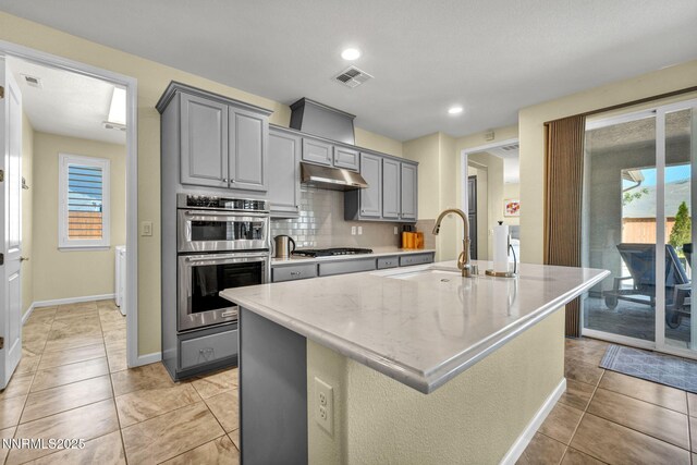 2222 Nasrullah Ln, Reno, NV 89521 - kitchen with gray cabinets, stainless steel appliances, under cabinet range hood, backsplash, and recessed lighting