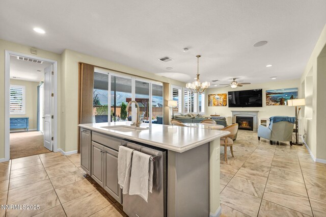 2222 Nasrullah Ln, Reno, NV 89521 - kitchen with dishwasher, a glass covered fireplace, light countertops, a kitchen island with sink, and plenty of natural light
