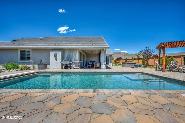 2222 Nasrullah Ln, Reno, NV 89521 - view of swimming pool featuring a covered hot tub, a patio, grilling area, a pergola, and a mountain view