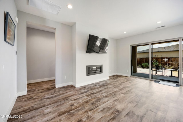 698 Raptor Way, Fernley, NV 89408 - unfurnished living room featuring wood finished floors, a glass covered fireplace, and recessed lighting
