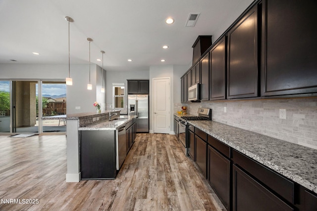 698 Raptor Way, Fernley, NV 89408 - kitchen featuring stainless steel appliances, light wood-style flooring, tasteful backsplash, light stone counters, and recessed lighting