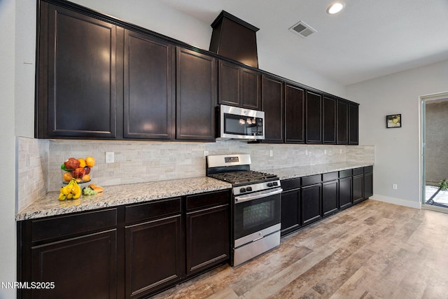 698 Raptor Way, Fernley, NV 89408 - kitchen with appliances with stainless steel finishes, light wood-style floors, tasteful backsplash, light stone counters, and recessed lighting
