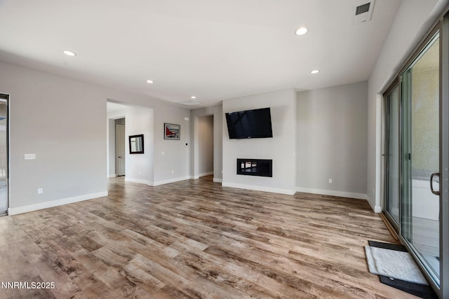 698 Raptor Way, Fernley, NV 89408 - unfurnished living room featuring wood finished floors, recessed lighting, and a glass covered fireplace