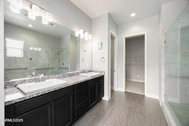 698 Raptor Way, Fernley, NV 89408 - bathroom featuring walk in shower, double vanity, a spacious closet, and wood finished floors