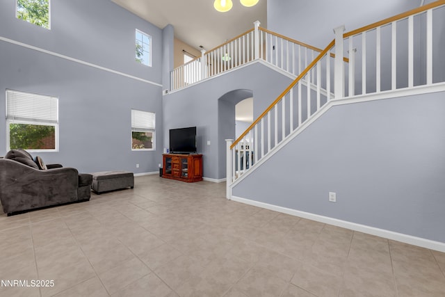 10509 Yuba Ct, Reno, NV 89521 - tiled living room featuring a high ceiling, arched walkways, and stairs