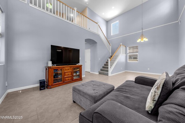 10509 Yuba Ct, Reno, NV 89521 - living area with tile patterned floors, stairs, a high ceiling, arched walkways, and a chandelier