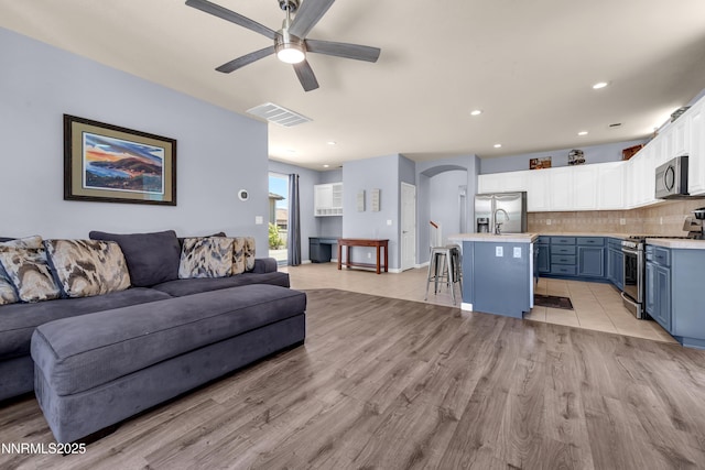 10509 Yuba Ct, Reno, NV 89521 - living area featuring a ceiling fan, light wood-style floors, arched walkways, and recessed lighting