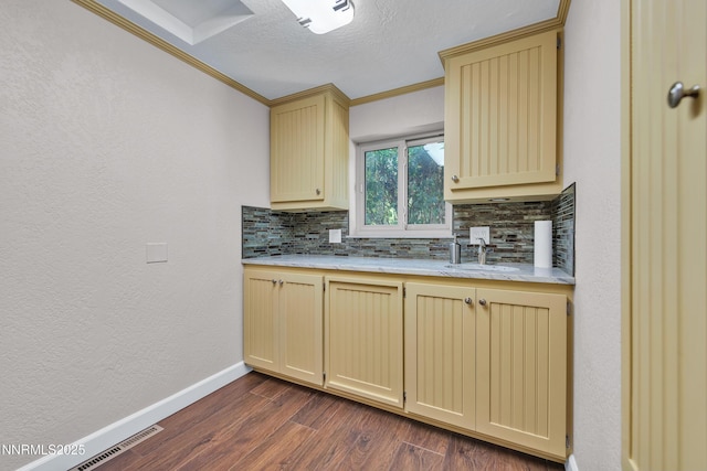1401 Jefferson Dr, Carson City, NV 89706 - kitchen featuring cream cabinets, backsplash, crown molding, dark wood-style floors, and a textured wall