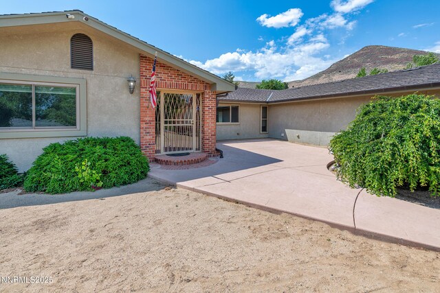 1401 Jefferson Dr, Carson City, NV 89706 - property entrance with stucco siding, a patio area, and brick siding