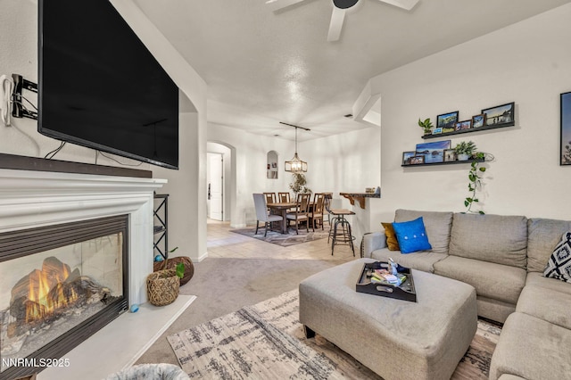 9900 Wilbur May Pkwy Apt 5102, Reno, NV 89521 - living area featuring arched walkways, a ceiling fan, a glass covered fireplace, and carpet