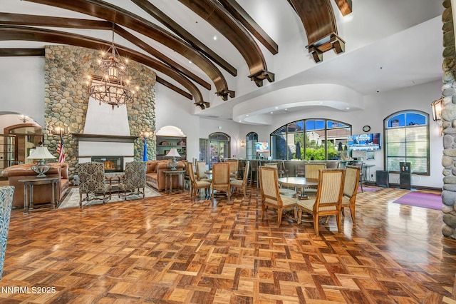 9900 Wilbur May Pkwy Apt 5102, Reno, NV 89521 - dining area featuring high vaulted ceiling, a chandelier, a glass covered fireplace, and beamed ceiling