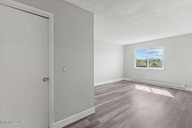 2090 Highview Ct Unit 7, Reno, NV 89512 - empty room with a baseboard radiator, wood finished floors, and a textured ceiling