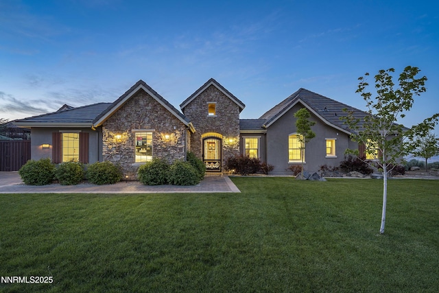 5427 Salmon River Ct, Reno, NV 89511 - view of front of home featuring stone siding, a front lawn, a tiled roof, and stucco siding